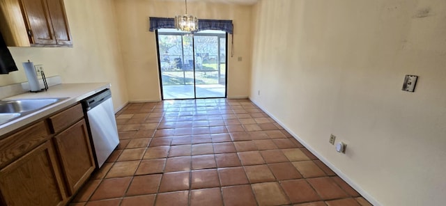 kitchen with brown cabinets, a chandelier, tile patterned flooring, dishwasher, and baseboards