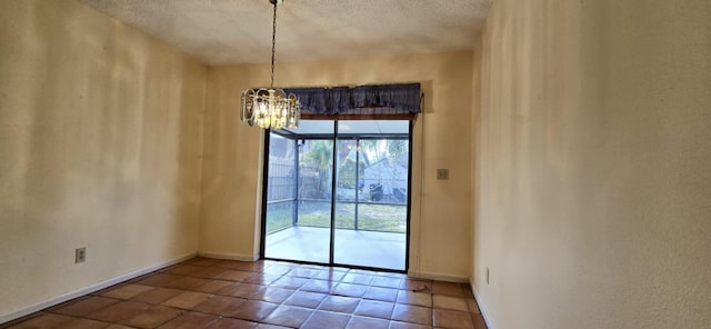 empty room featuring a chandelier, a textured ceiling, baseboards, and tile patterned floors