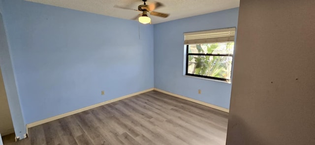 unfurnished room featuring a textured ceiling, ceiling fan, wood finished floors, and baseboards