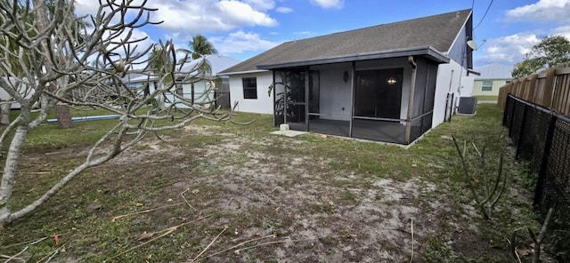 5724 SE Collins Ave, Stuart, FL 34997 - back of property featuring a sunroom, a shingled roof, and central AC