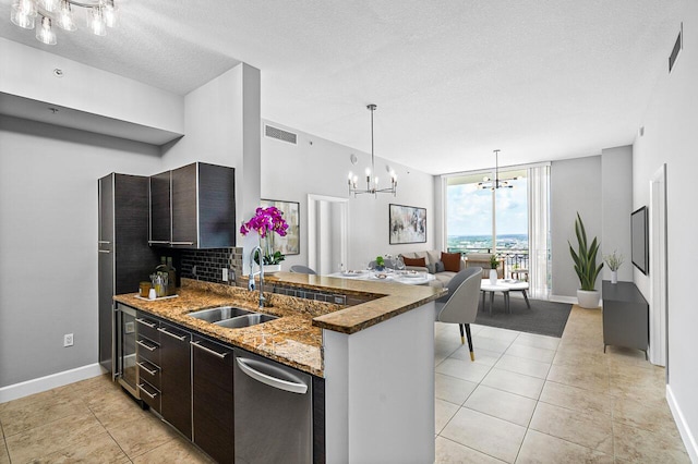 kitchen featuring visible vents, a sink, dark brown cabinetry, and an inviting chandelier