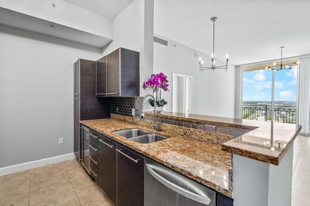 kitchen with dark brown cabinetry, a peninsula, a sink, visible vents, and stainless steel dishwasher