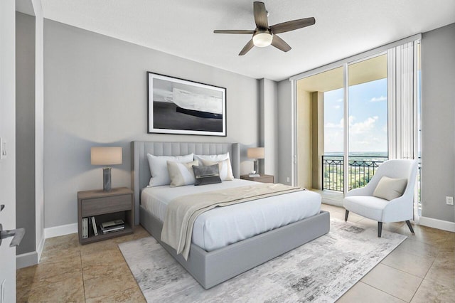 bedroom featuring access to exterior, floor to ceiling windows, light tile patterned flooring, a textured ceiling, and baseboards