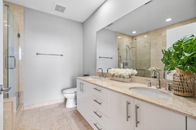 bathroom with toilet, double vanity, a sink, and visible vents