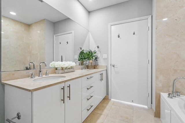 full bathroom with a bath, double vanity, a sink, and tile patterned floors