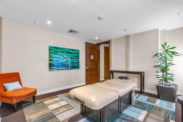 bedroom featuring baseboards, visible vents, and wood finished floors