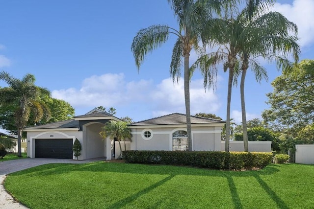 mediterranean / spanish home featuring stucco siding, an attached garage, decorative driveway, and a front lawn