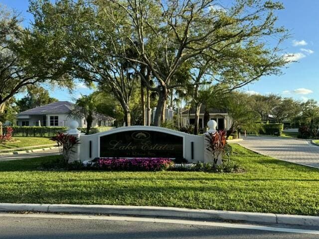 community sign featuring a lawn