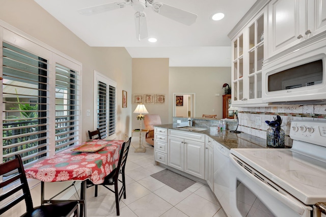 kitchen featuring a peninsula, white appliances, white cabinets, and decorative backsplash