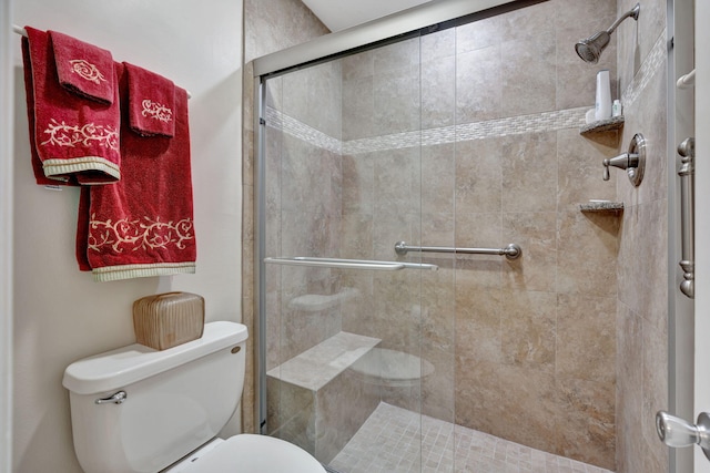 bathroom with a shower stall and toilet