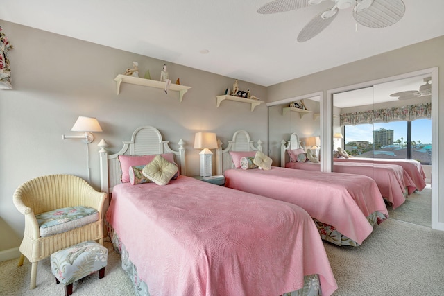 bedroom with a ceiling fan, carpet flooring, and two closets