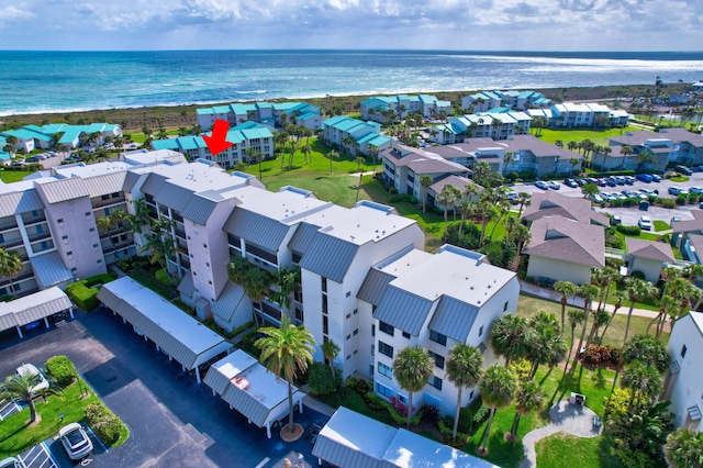 drone / aerial view featuring a view of the beach, a residential view, and a water view