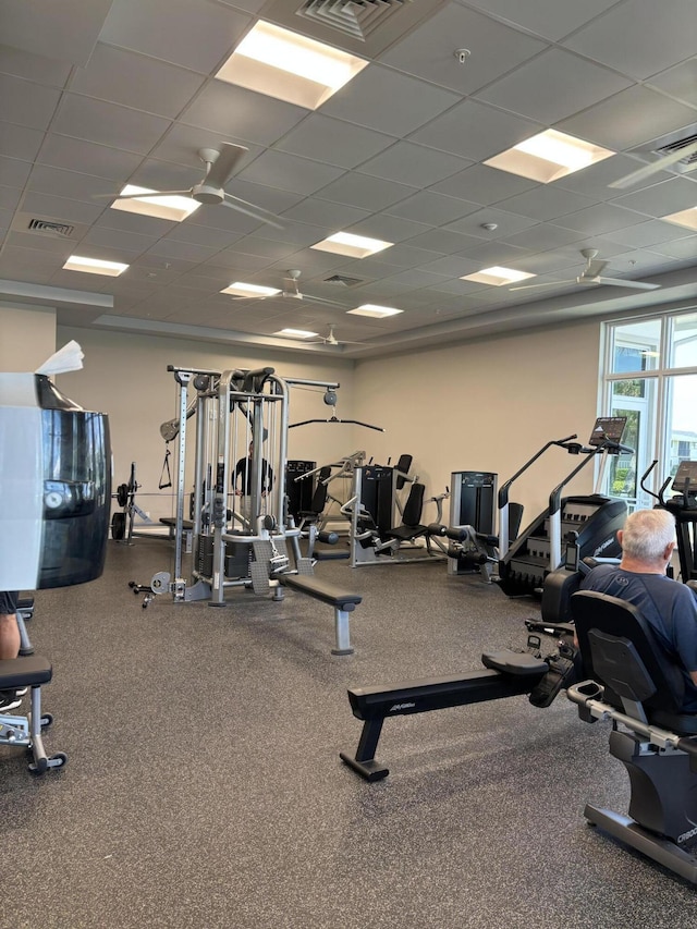 gym with a paneled ceiling and visible vents