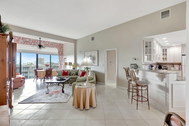 living area with baseboards, visible vents, and light tile patterned flooring