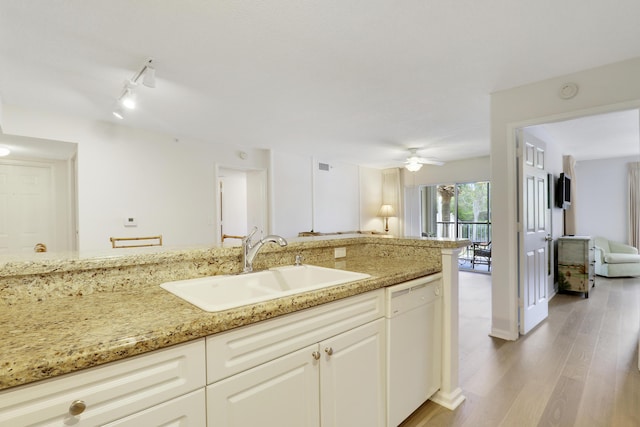 kitchen featuring white cabinets, light stone countertops, white dishwasher, light wood-type flooring, and a sink