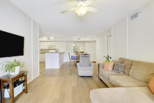 living area featuring ceiling fan, light wood-style flooring, visible vents, baseboards, and track lighting