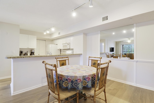 dining area featuring light wood-type flooring, baseboards, and visible vents