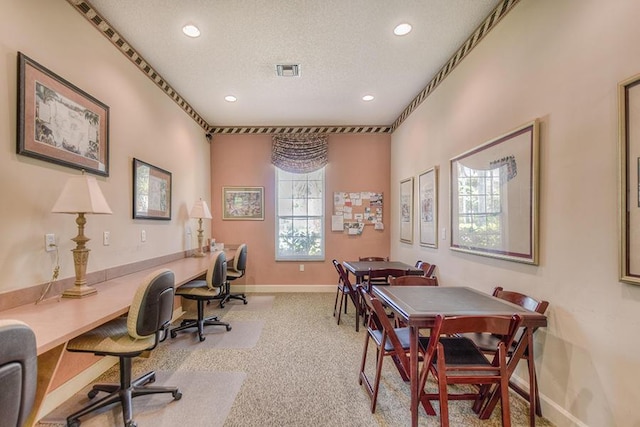 carpeted home office with a textured ceiling, recessed lighting, visible vents, baseboards, and built in study area