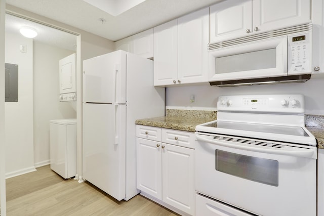 kitchen featuring white appliances, electric panel, light wood-style flooring, stacked washing maching and dryer, and white cabinetry