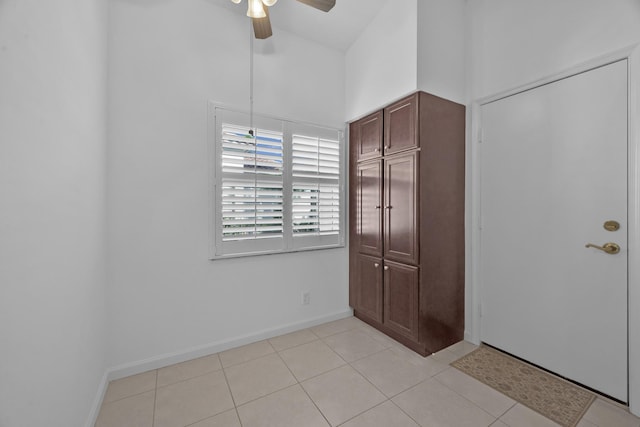 unfurnished bedroom with a ceiling fan, light tile patterned flooring, and baseboards