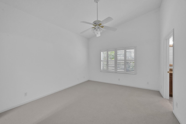 spare room featuring vaulted ceiling, ceiling fan, baseboards, and light colored carpet