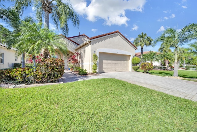 mediterranean / spanish house featuring a garage, a front yard, a tile roof, and stucco siding