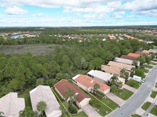 drone / aerial view featuring a residential view and a view of trees