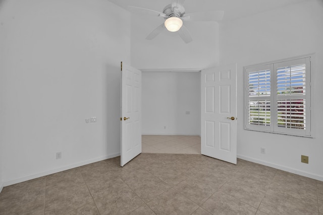 unfurnished bedroom featuring ceiling fan, tile patterned flooring, and baseboards