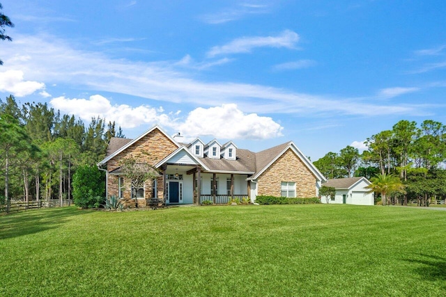 view of front of home with covered porch, stone siding, a front lawn, and fence