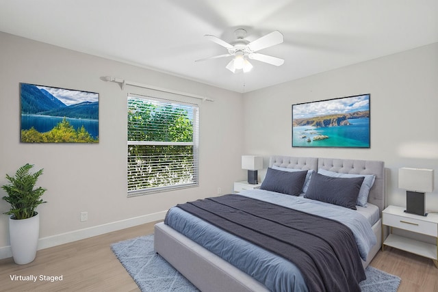 bedroom with a ceiling fan, light wood-style flooring, and baseboards