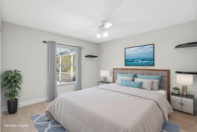 bedroom with a ceiling fan, light wood-style flooring, and baseboards