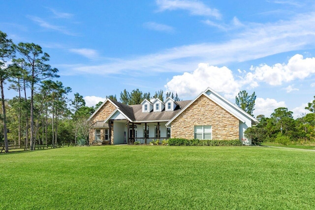 view of front of property with stone siding, a front lawn, and a porch