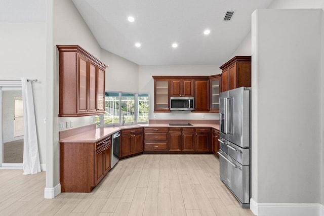 kitchen with visible vents, light countertops, appliances with stainless steel finishes, and glass insert cabinets