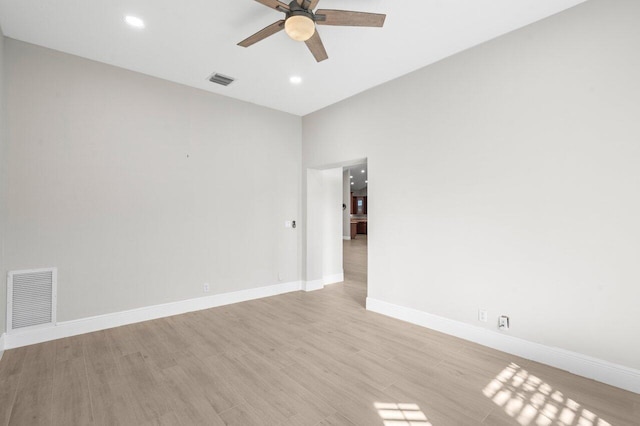 spare room featuring light wood finished floors, baseboards, visible vents, and a ceiling fan