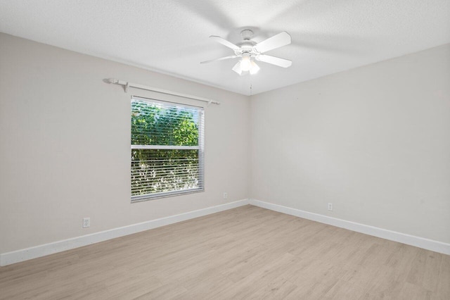 unfurnished room with a textured ceiling, ceiling fan, light wood finished floors, and baseboards