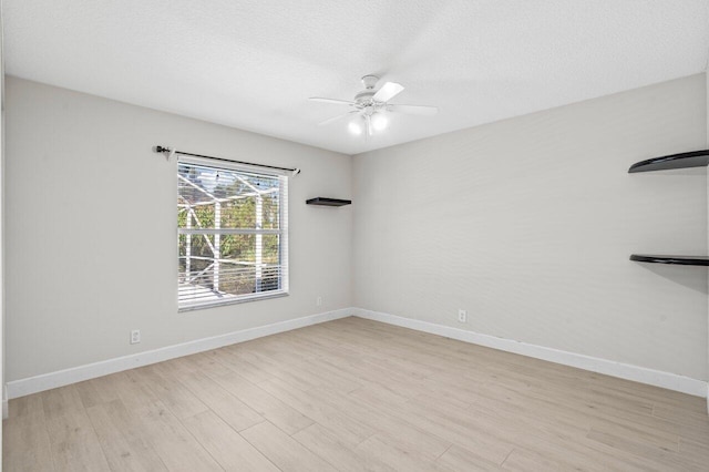 unfurnished room with baseboards, a textured ceiling, light wood-style flooring, and a ceiling fan