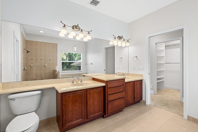 bathroom with visible vents, a sink, a tile shower, and double vanity