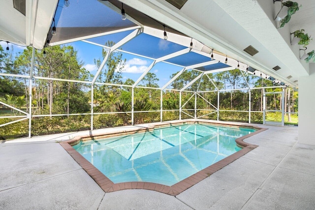 outdoor pool with glass enclosure and a patio