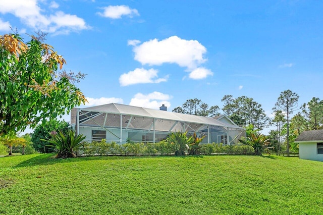 back of property featuring glass enclosure, a yard, and a chimney