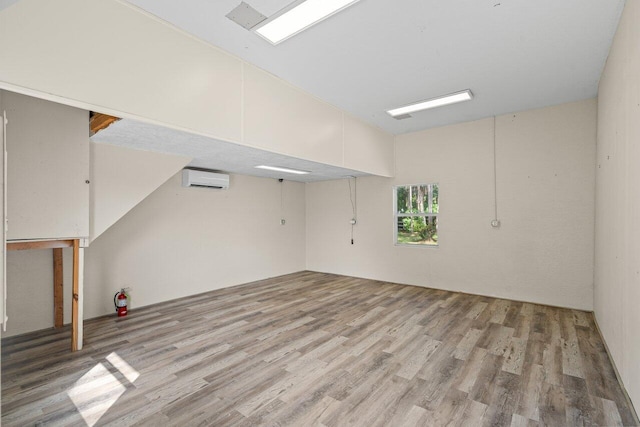 unfurnished room with a wall unit AC and light wood-style flooring