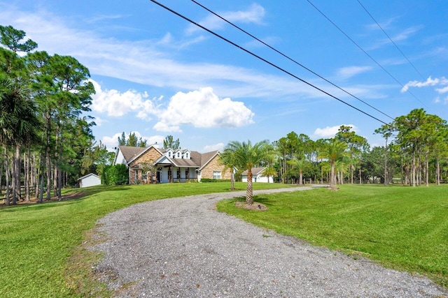 view of front of property with gravel driveway and a front lawn