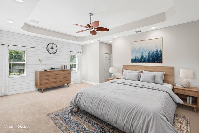 bedroom featuring light carpet, visible vents, a ceiling fan, a tray ceiling, and recessed lighting