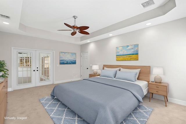 bedroom with light carpet, visible vents, a raised ceiling, and french doors