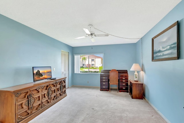 carpeted home office featuring ceiling fan and baseboards