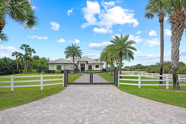 view of gate with a fenced front yard and a lawn