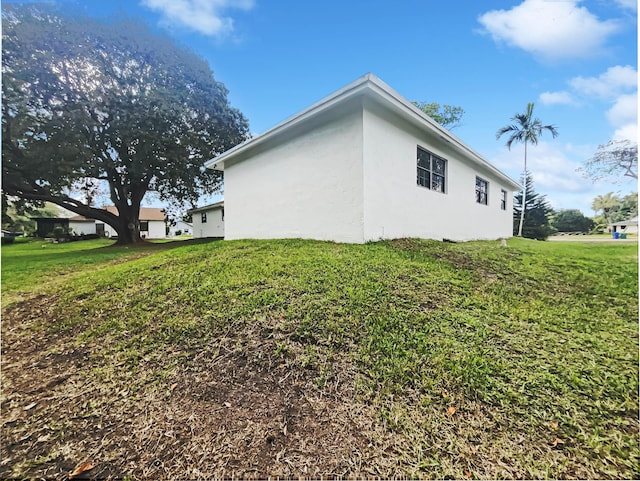 view of home's exterior with a lawn and stucco siding