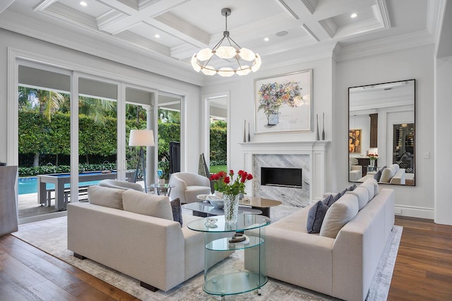 living room featuring wood finished floors, coffered ceiling, a premium fireplace, beam ceiling, and crown molding