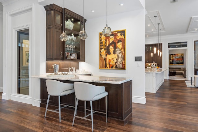 bar featuring visible vents, wet bar, dark wood finished floors, and hanging light fixtures