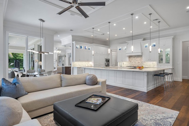 living area featuring baseboards, dark wood finished floors, ornamental molding, recessed lighting, and a ceiling fan