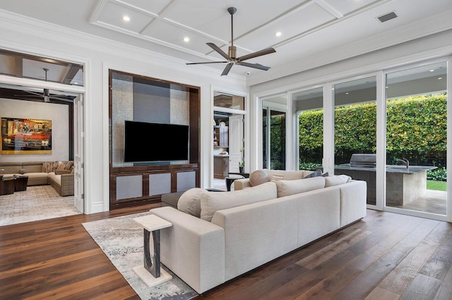 living area with visible vents, ceiling fan, ornamental molding, wood finished floors, and coffered ceiling